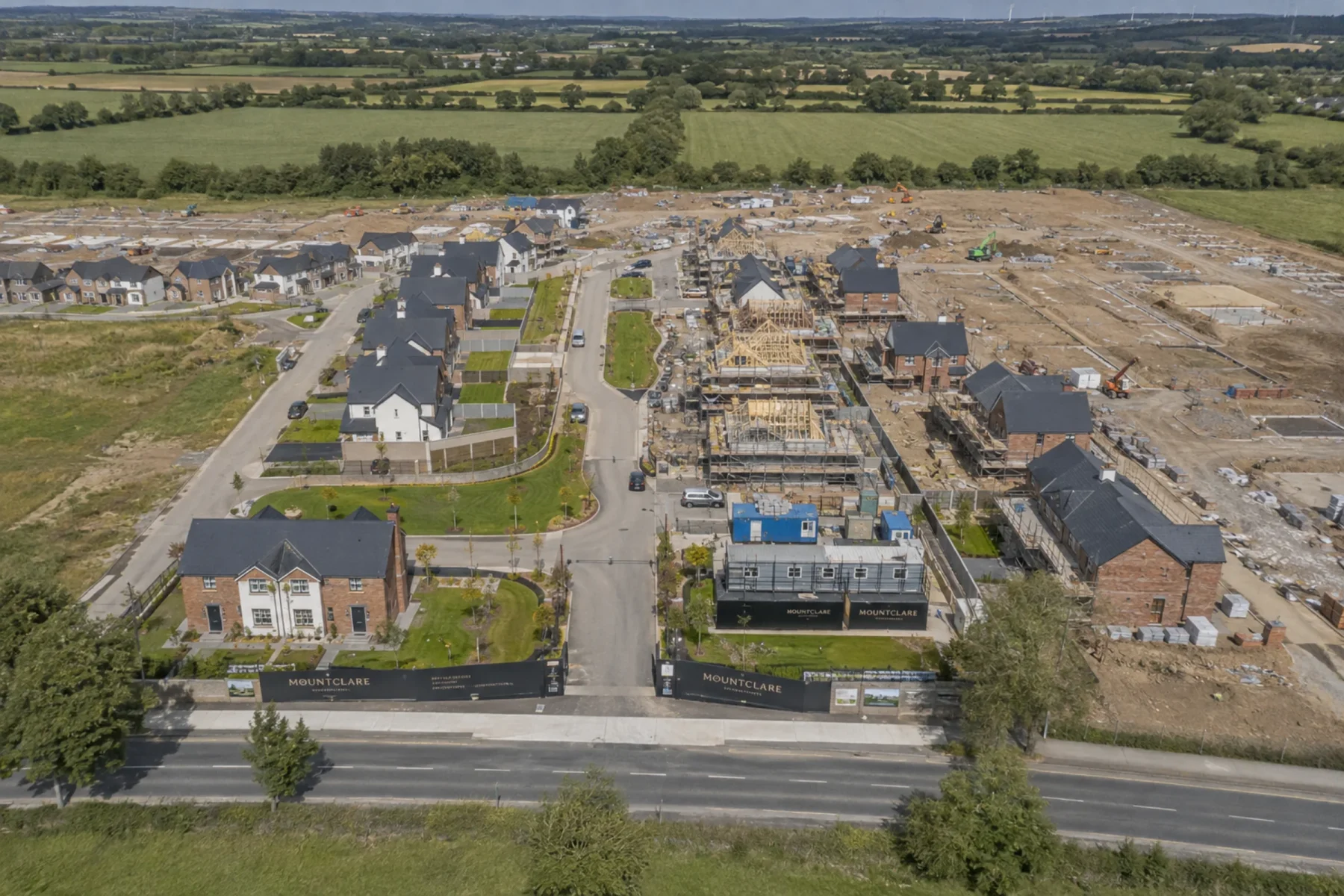 Aerial view of a Mountclare residential development showing completed housing, active construction and future development land
